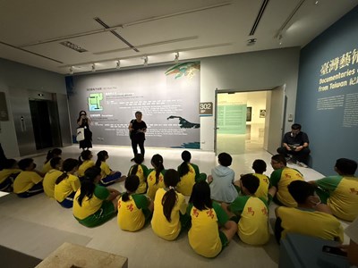 圖1：巫老師向來參與活動的學生解紹展覽主題_0_0