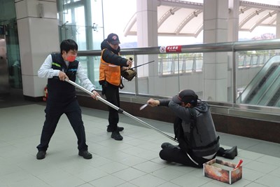 台中捷運站長與保全持防護設備與行為異常旅客對峙。