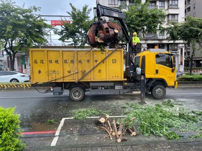 清潔隊運用抓斗車吊運大型樹幹。