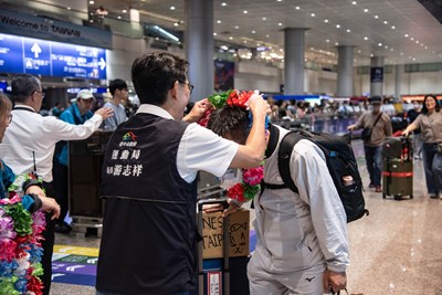 運動局長為歸國選手戴上花圈