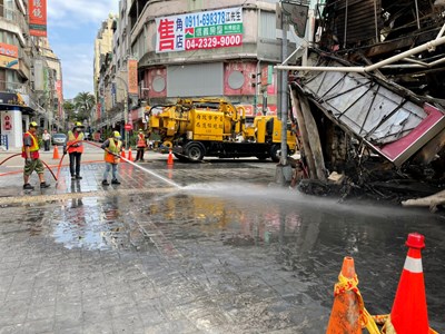 環保局調度灑水車清洗街道上的塵土及灰燼,完成周圍整體清潔