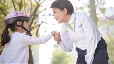 盧市長溫柔牽起坐在地上哭泣女孩的手,微笑為女孩加油打氣