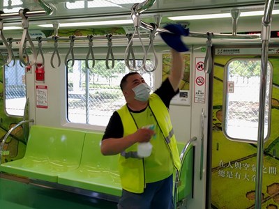 清潔人員消毒捷運車廂內的扶手、拉環。