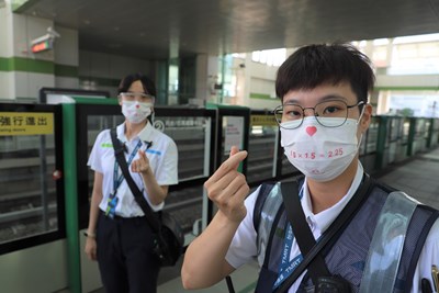 疫情降級首日，台中捷運站務員戴上「愛的距離」口罩，提醒民眾戴口罩、保持社交距離