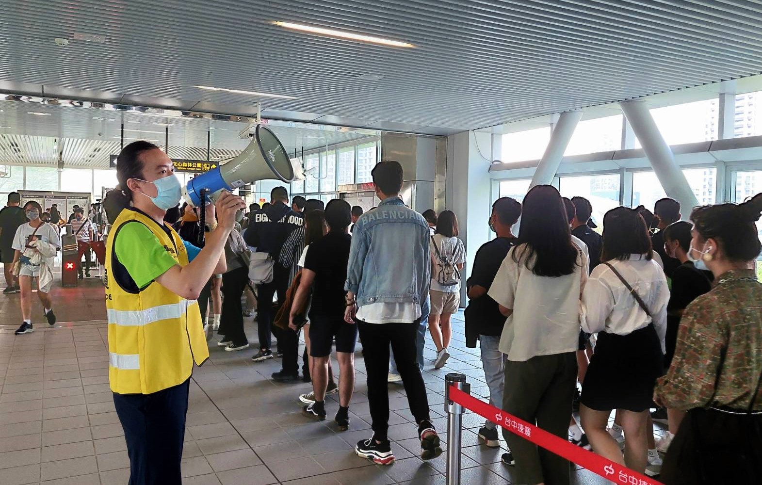 捷運文心森林公園站車站人員引導旅客出站。