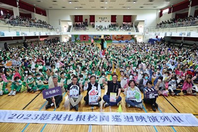 2023影視扎根巡映列車開入校園,新聞局長鄭照新(右三) 、教育局主秘郭明洲(左三)、北屯國小校長蔡添財(左一)與全校千位師生大合影